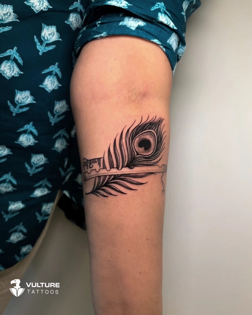 Krishna Peacock Feather Armband — tattoo by Vulture Tattoos, Gurugram