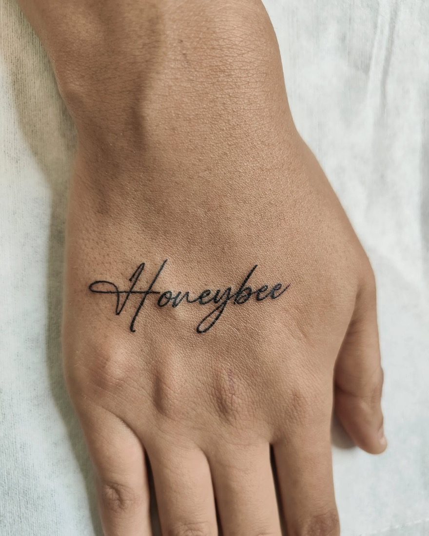 Honeybee Cursive Hand Script — tattoo by Vulture Tattoos, Gurugram