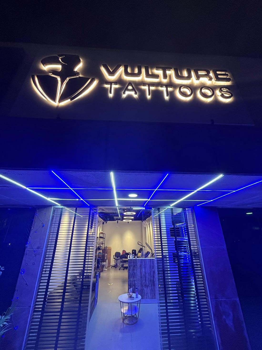 Vulture Tattoos neon storefront at night