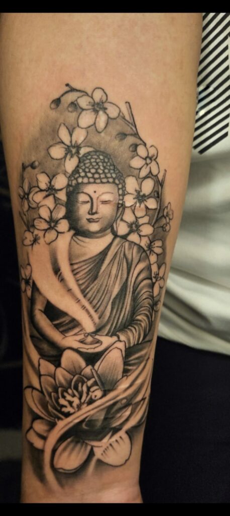 Meditating Buddha tattoo in black and grey on upper arm, Vulture Tattoos Gurgaon
