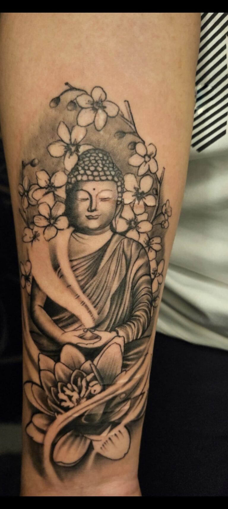 Meditating Buddha tattoo in black and grey on upper arm, Vulture Tattoos Gurgaon